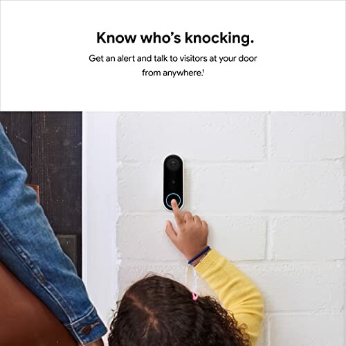 Child pressing smart doorbell on wall